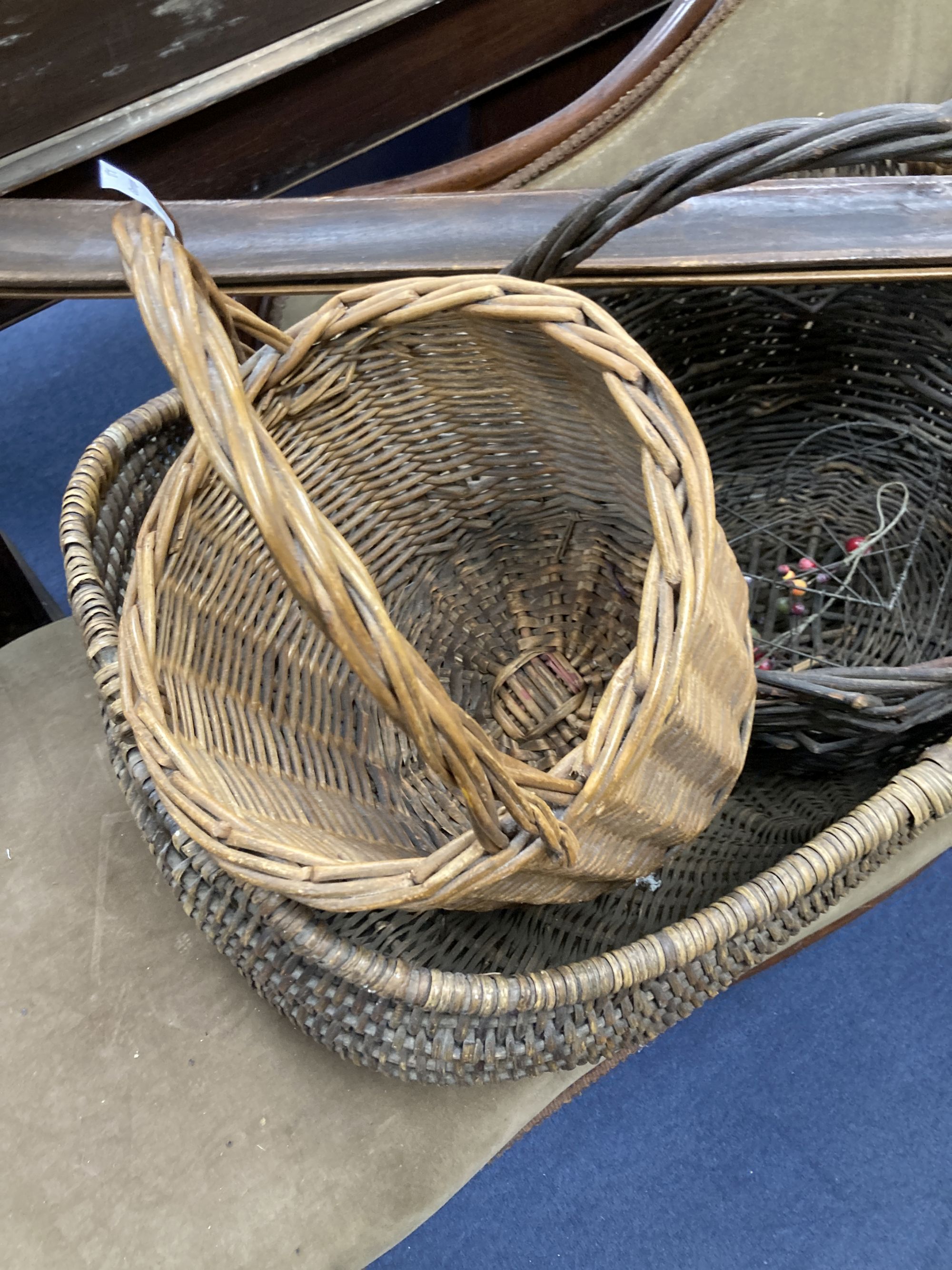 Three wicker baskets, a wirework basket and two baguette stands